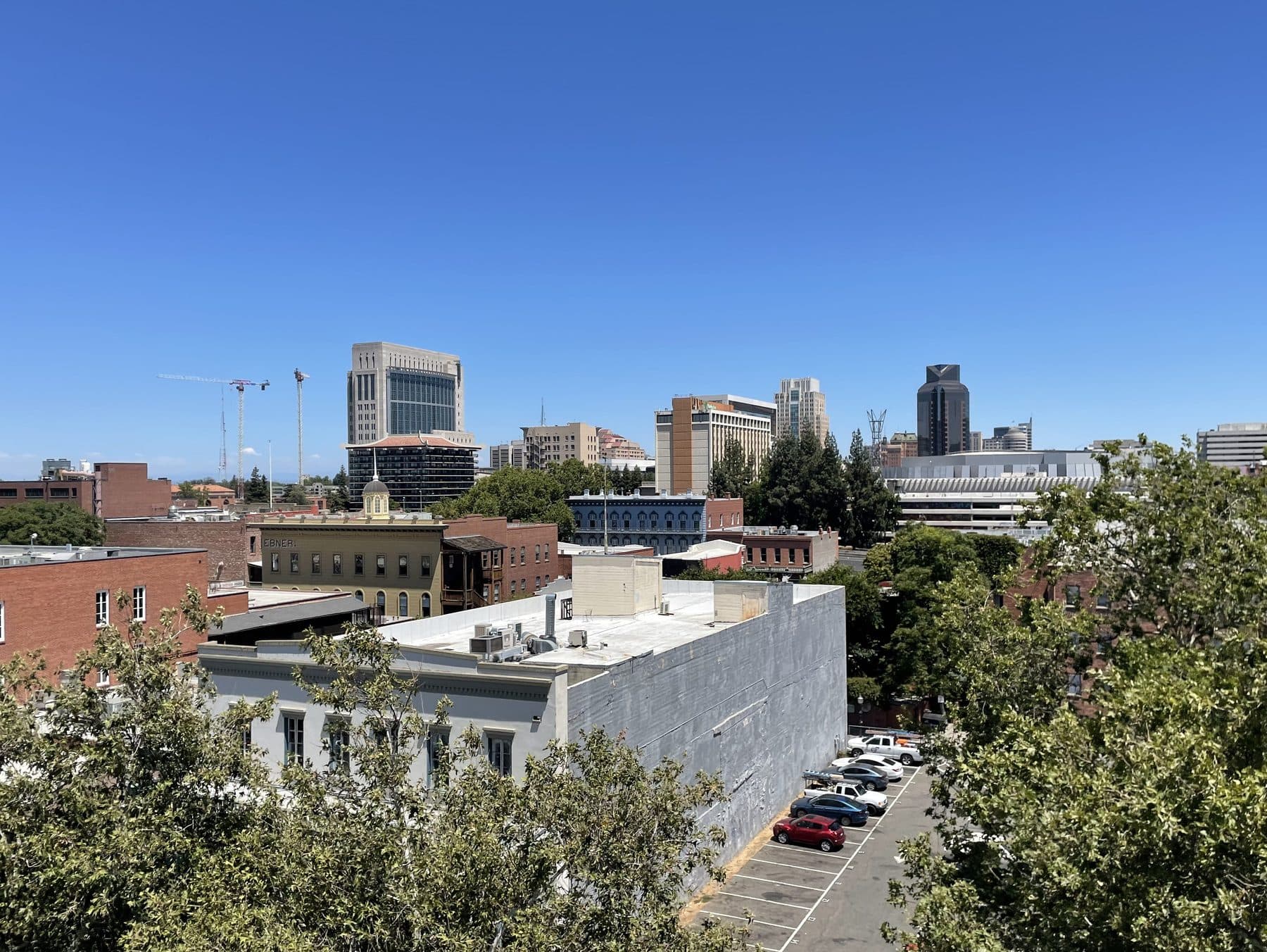 The downtown Sacramento skyline seen over the brick rooftops of the Old Sacramento historic district